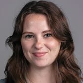 Samantha Grindell's face on a gray background.